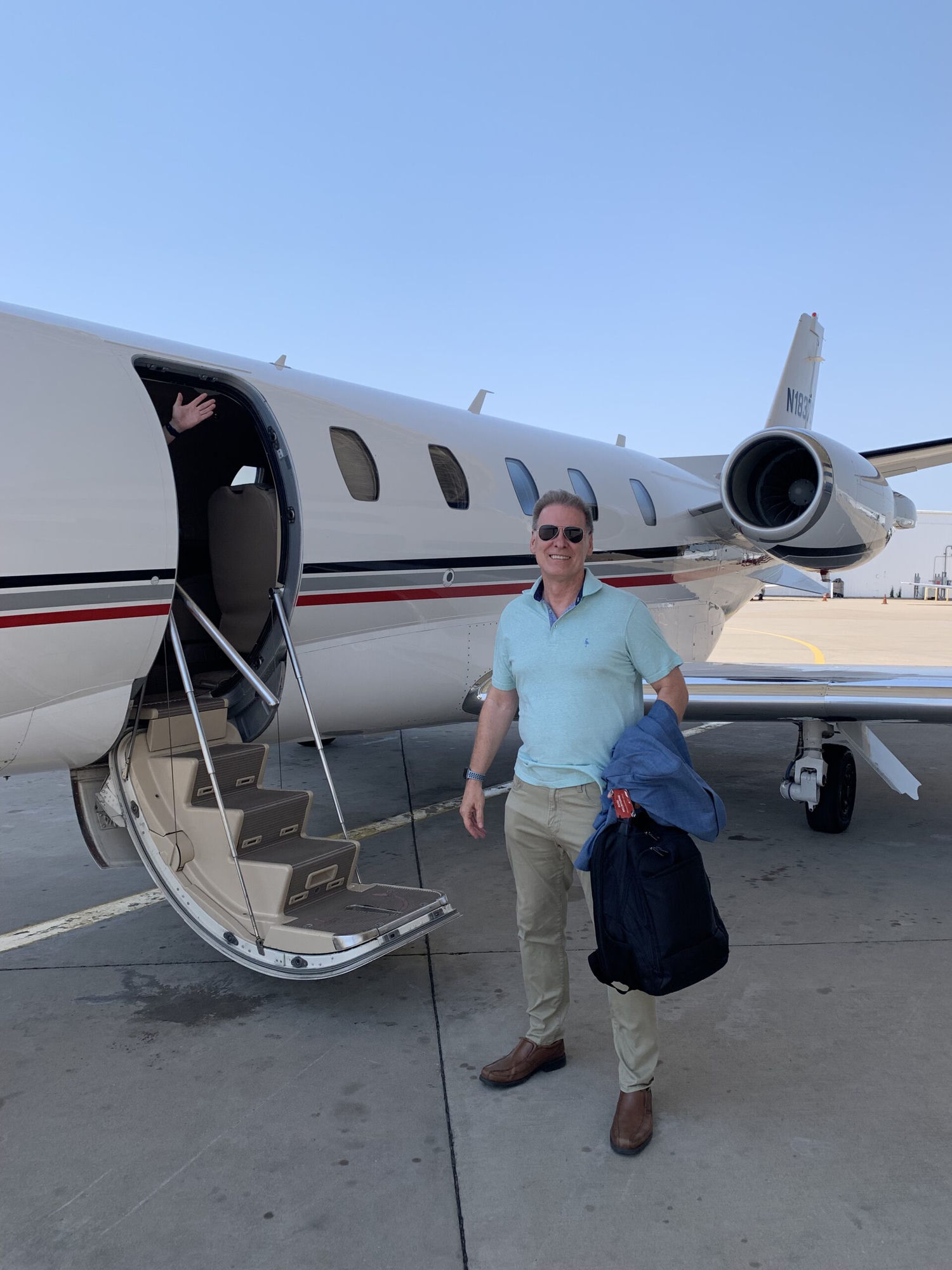 Ross Melbourne beside a private jet
